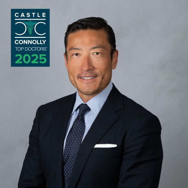A man in a dark suit and tie poses for a professional portrait. The image includes a "Castle Connolly Top Doctors 2025" badge in the top left corner.